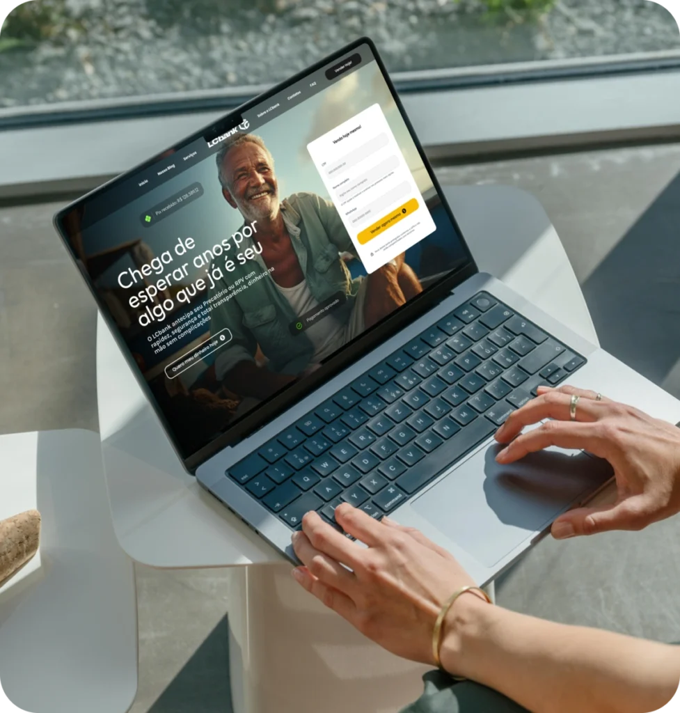Laptop aberto exibindo o site do LCbank com homem sorrindo.