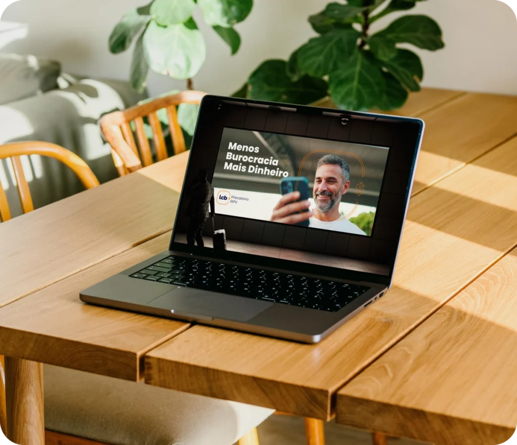 Laptop exibindo vídeo do LCbank sobre menos burocracia e mais dinheiro.